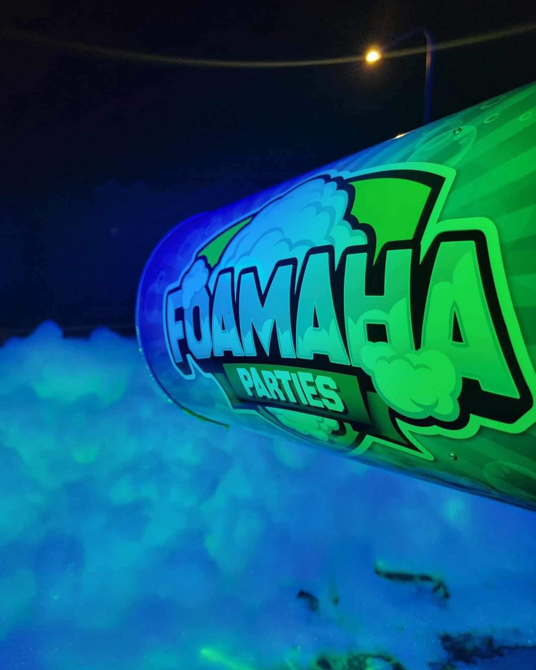 Glow foam cannon lighting up a nighttime crowd