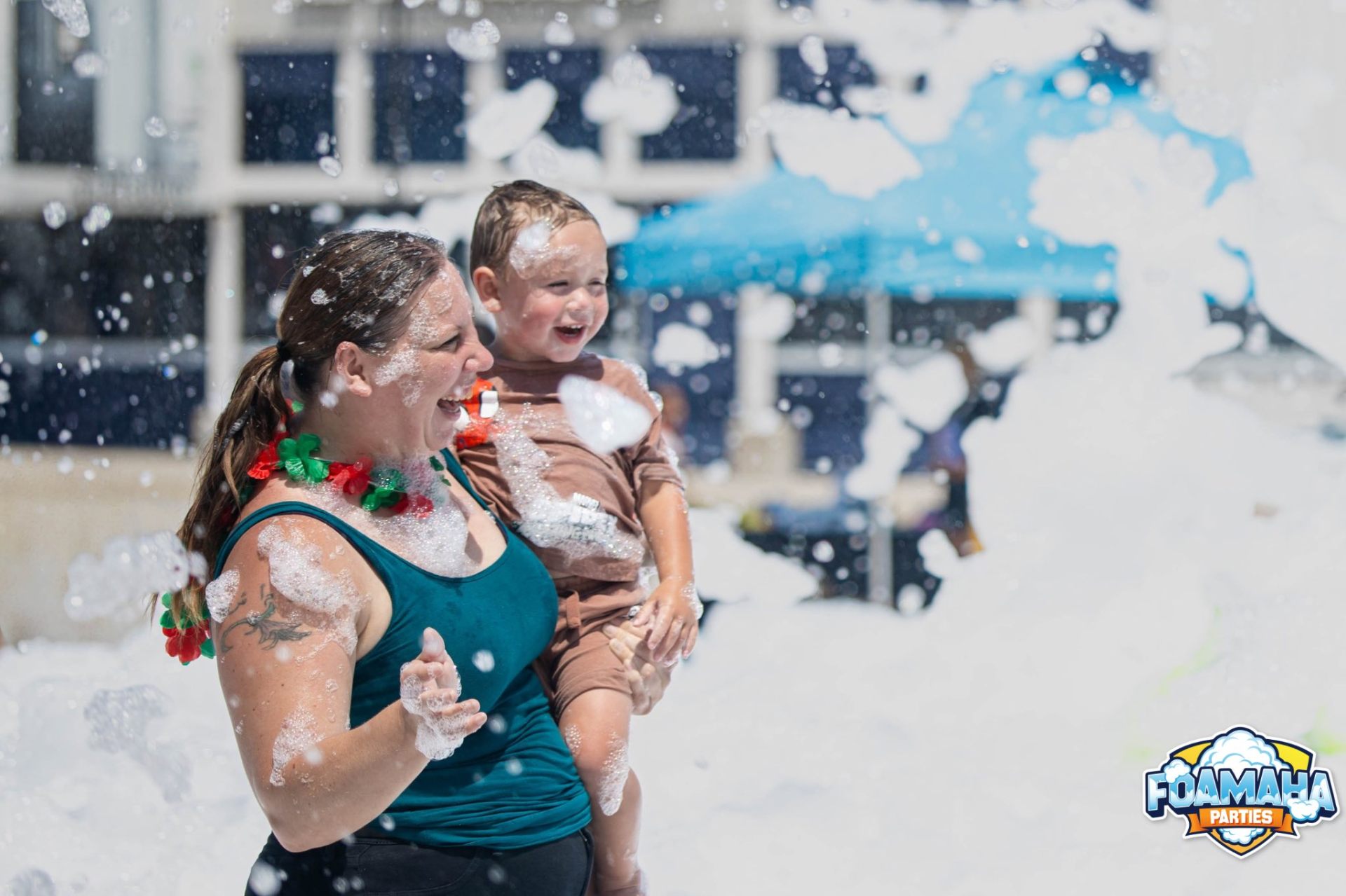 Mom and toddler laughing together covered in foam at a Foamaha party
