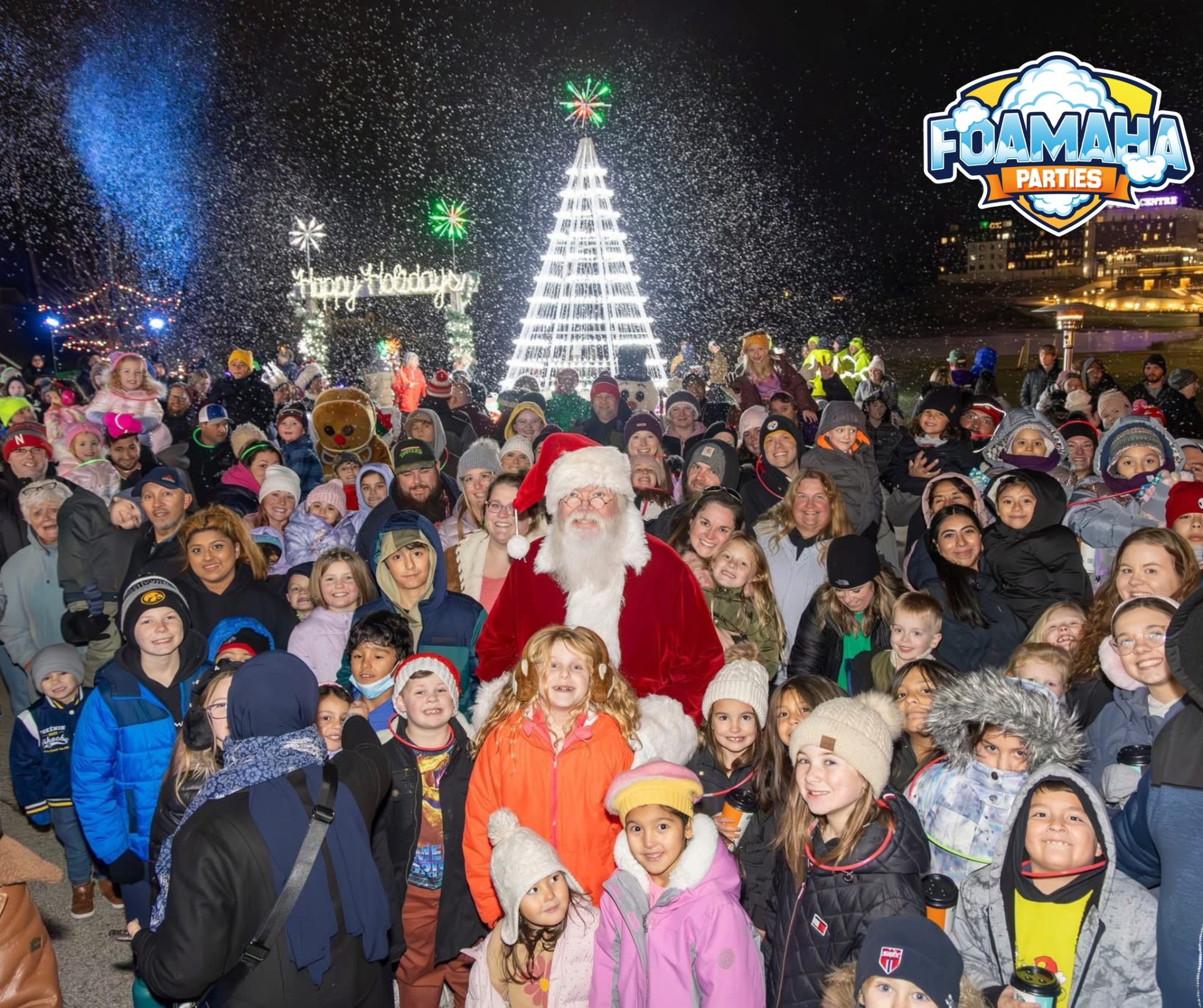 Huge crowd with Santa under falling Foamaha snow at a holiday tree lighting