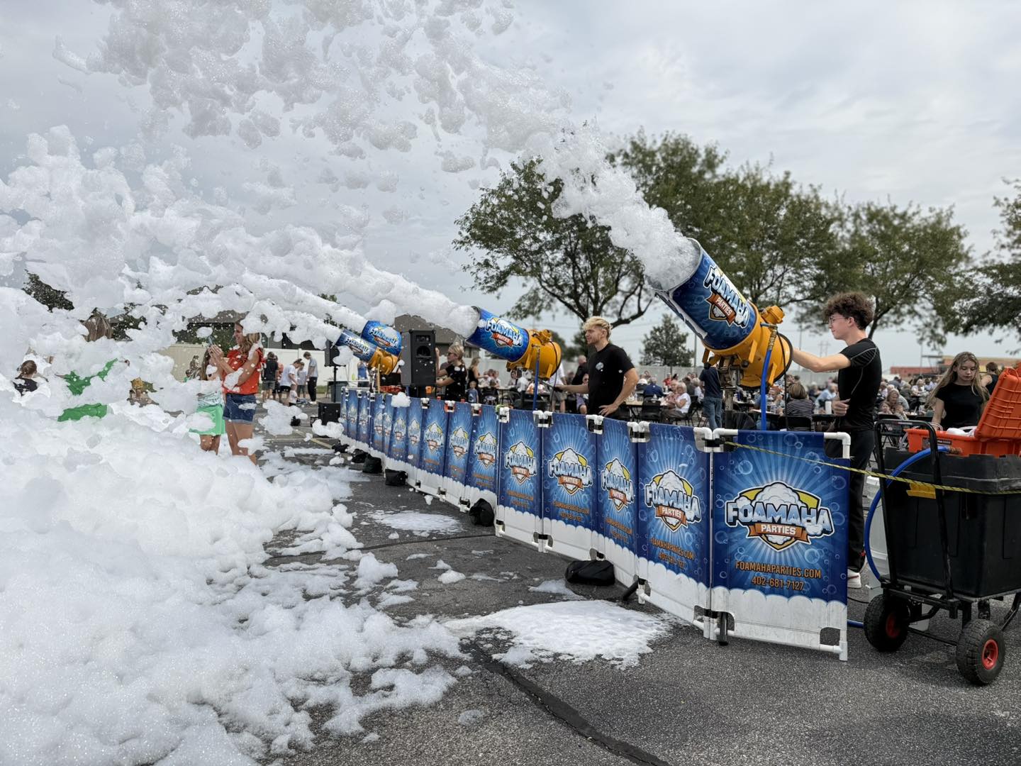 Row of Foamaha foam cannons firing white foam over a crowd